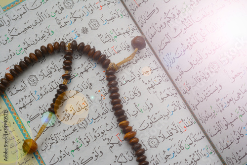 Closeup tasbih (beads) over the Holy Koran verse. Holy Koran is the greatest book in Islam.