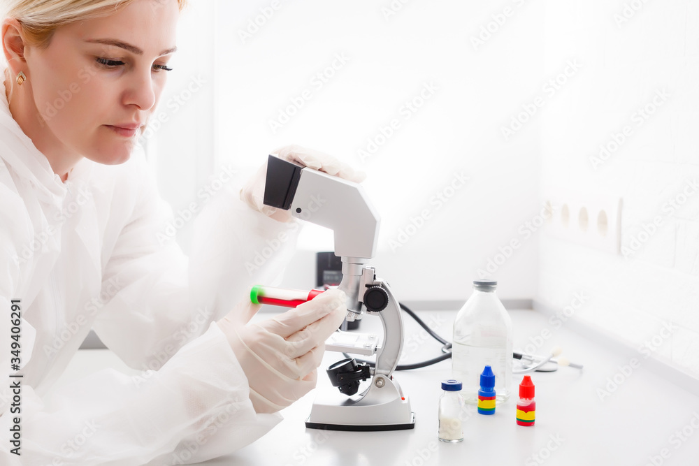 A beautiful female medical or scientific researcher using her microscope in a laboratory. A beautiful female medical or scientific researcher using her microscope in a laboratory.
