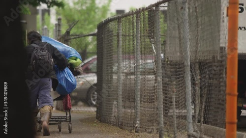 PORTLAND, OR - May 2020: Homeless man pushing a shopping cart