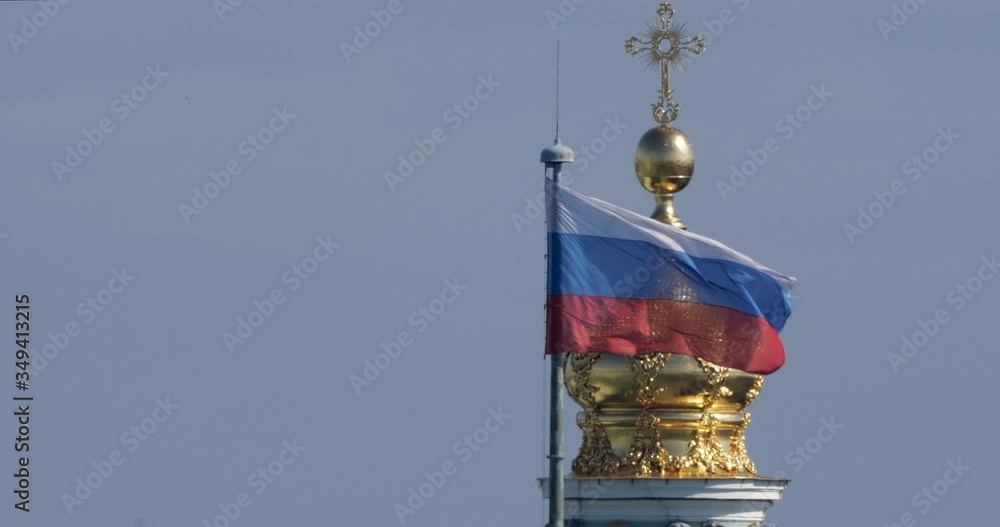 The Russian flag sways in the wind against the background of the Golden Dome of the Hermitage. The Winter Palace and the Russian flag in Saint-Petersburg against the sky. The Russian flag sways in the wind against the background of the Golden Dome of the Hermitage. The Winter Palace and the Russian flag in Saint-Petersburg against the sky.