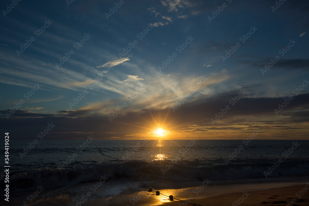 Sunset on a sea beach with fantastic sky clouds. Amazing sunset vacation in Asia. Mai Khao beach in Phuket, Thailand. Exotic sea view at dusk