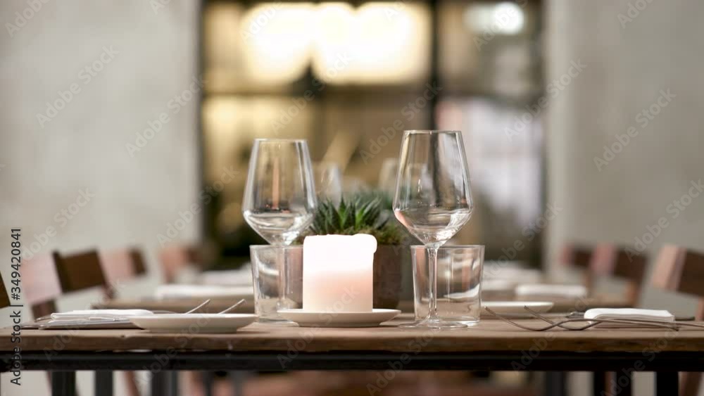 close up of a young blond waitress preparing the table in a restaurant. A beautiful lady sets a candle then she blows it out. close up of a young blond waitress preparing the table in a restaurant. A beautiful lady sets a candle then she blows it out.