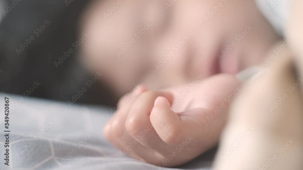 Cute Asian baby girl sleeping peacefully, hand twitching in foreground Cute Asian baby girl sleeping peacefully, hand twitching in foreground