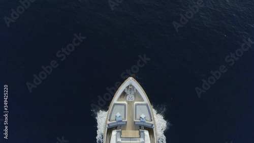 AERIAL DRONE CLOSE STILL TOP-DOWN ZENITHAL VIEW OF LUXURY YACHT SAILING IN BLUE DEEP SEA AND WHITE FOAM