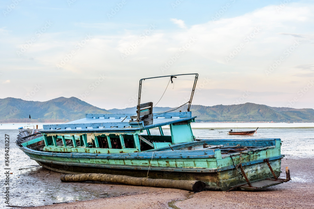 Fototapeta premium Old boat at low tide on Ko Yao Noi island in Phang-Nga Bay near Phuket in southern Thailand