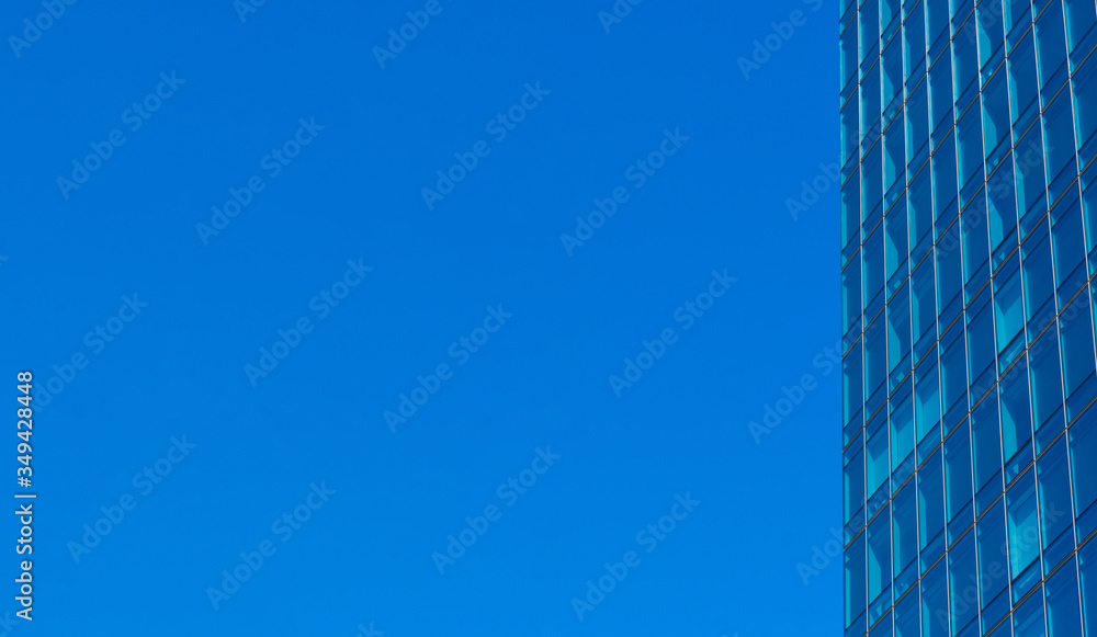View of typical glass wall facade of generic modern office skyscraper. Blue sky. View of typical glass wall facade of generic modern office skyscraper. Blue sky.