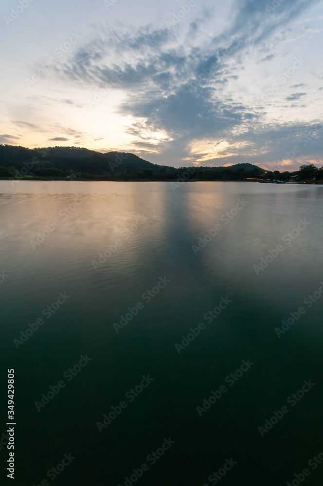 京都の池の水面に映る朝焼けの空