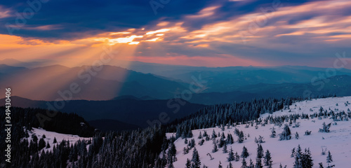 sunbeams through the clouds at sunrise on the snowy mountain