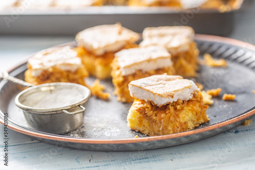 Cubes cut applie pie on a vintage tray with a sugar sieve and baking tray in the background