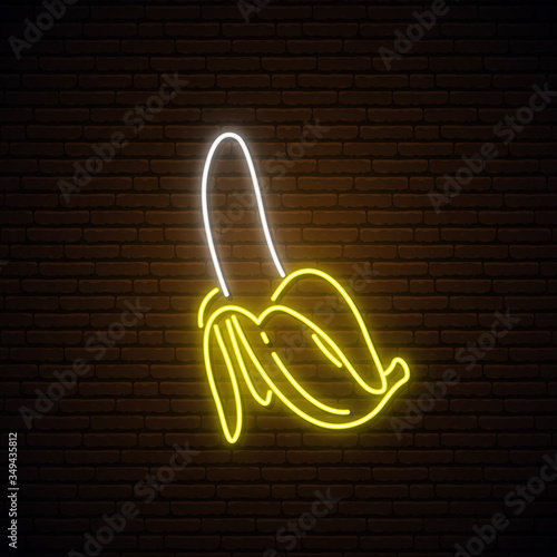 Neon banana sign. Bright glowing banana fruit icon on dark brick wall background. Stock vector illustration.