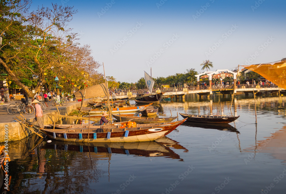 HOIAN, VIETNAM, SEPTEMBER, 04 2017: Traditional boats in front of ancient architecture in Hoi An, Vietnam. Hoi An is the World's Cultural heritage site, famous for mixed cultures architecture