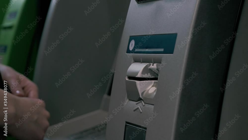 Close-up view of female hand inserting a credit card into an ATM machine. European woman using a cash machine withdrawing money in a bank. Close-up view of female hand inserting a credit card into an ATM machine. European woman using a cash machine withdrawing money in a bank.