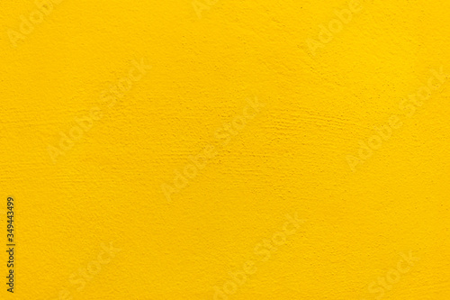 Blurred Yellow stucco wall background. Yellow painted cement wall texture.