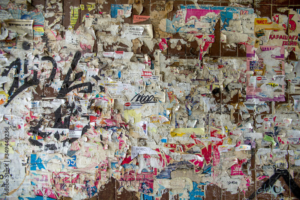 Fototapeta premium graffiti on the wall of ads with old ragged male information leaflets in the city on the wall of the house
