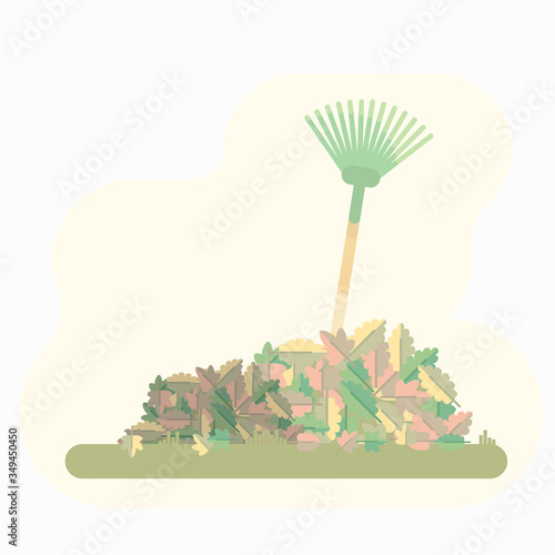 Image of a rake collecting heaps with autumn leaves. A rake is standing in a pile of leaves personifying a victory over autumn garden work.
