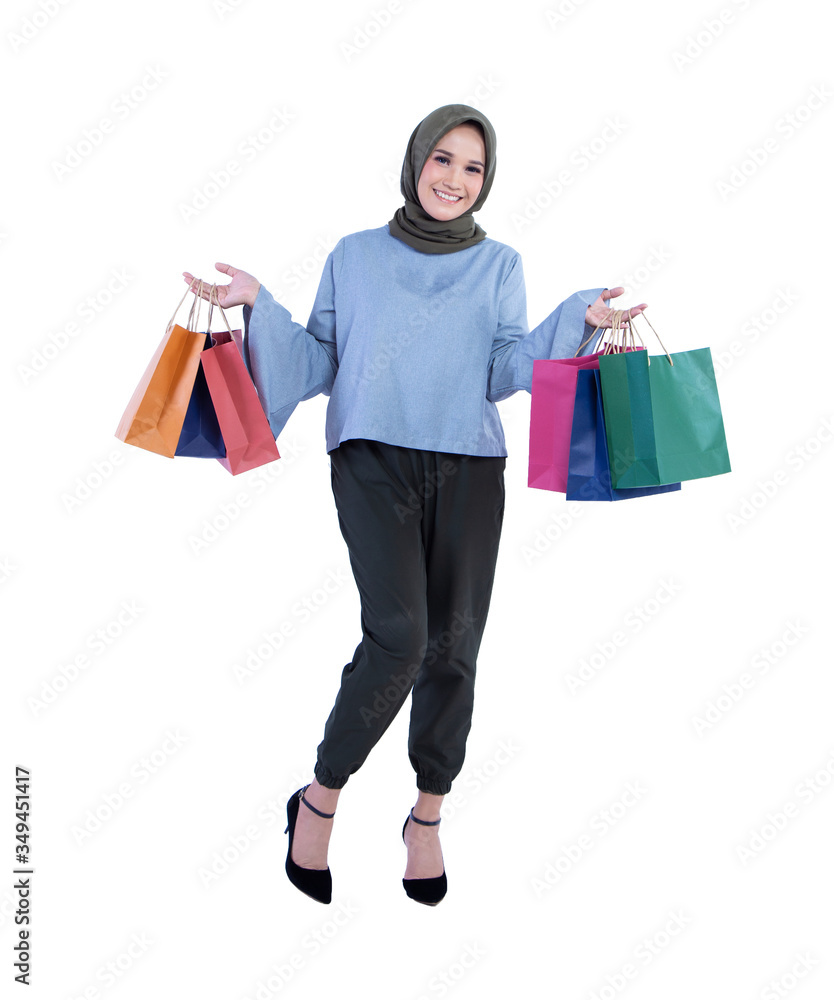Beautiful women of Muslim Indonesian is holding a shopping bag with a joyful expression isolated on white background
