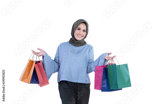 Beautiful women of Muslim Indonesian is holding a shopping bag with a joyful expression isolated on white background