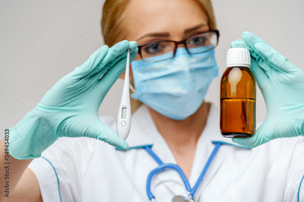 medical doctor nurse woman wearing protective mask and rubber or latex gloves - holding can of medicine and thermometer medical doctor nurse woman wearing protective mask and rubber or latex gloves - holding can of medicine and thermometer