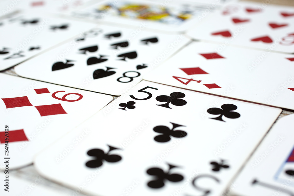 A closeup view of a background of random playing cards on a flat surface. A closeup view of a background of random playing cards on a flat surface.