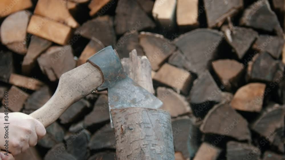 Chopping wood with an axe in woodpile - axe gets stuck in the log Chopping wood with an axe in woodpile - axe gets stuck in the log