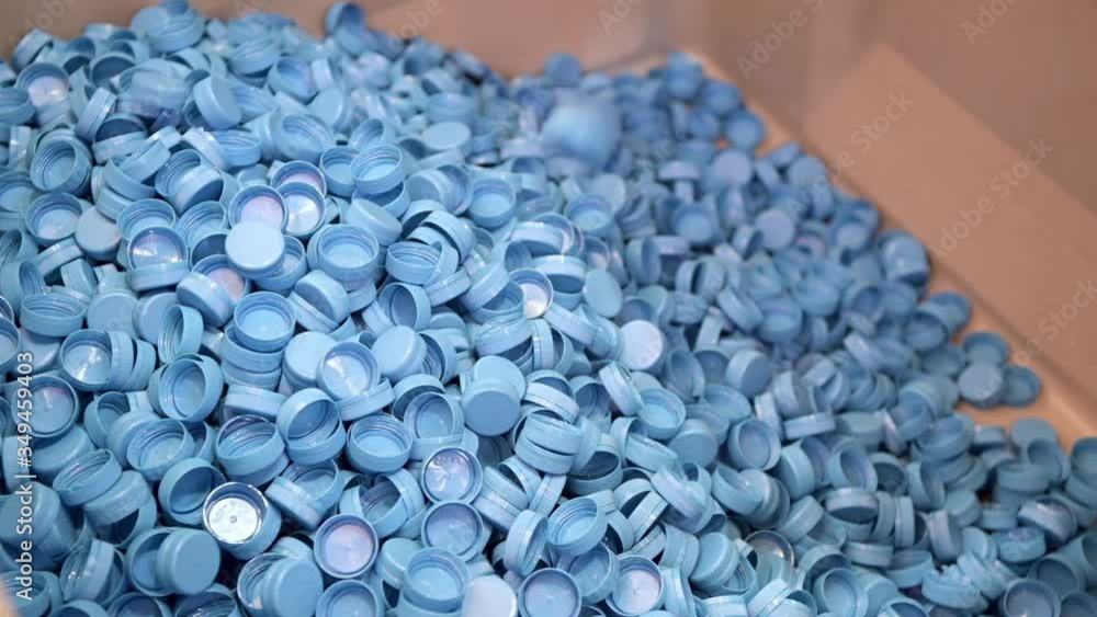 A bunch of plastic bottle caps. Blue caps fall from top to bottom A bunch of plastic bottle caps. Blue caps fall from top to bottom