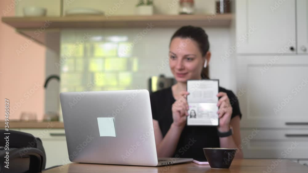 Young woman with passport and laptop doing e-verification by video call. Opening banking account Young woman with passport and laptop doing e-verification by video call. Opening banking account