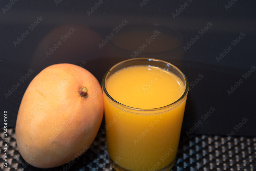 Mango juice (Mangifera indica) on dark background Mango juice (Mangifera indica) on dark background