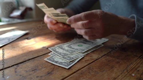 Elderly poor woman pensioner counts dollar bills of small denomination