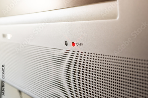 Foto A closeup view of a television set with a red illuminated light that remains on when the device is off