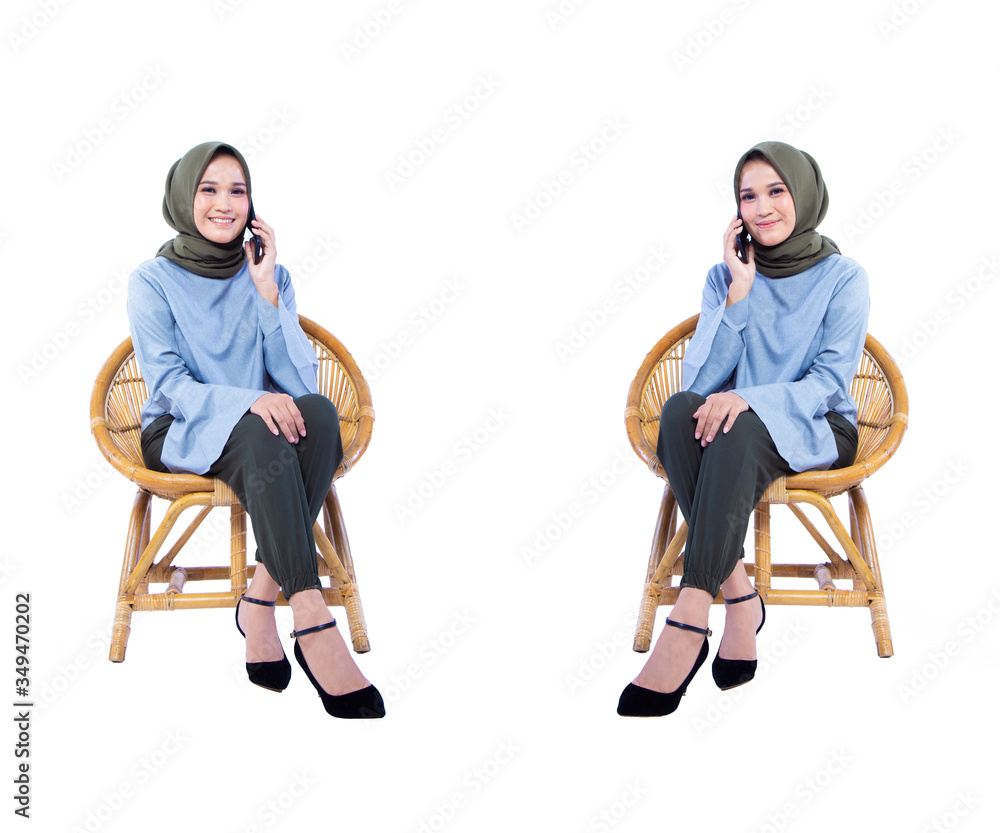 Obraz premium Beautiful Hijab woman sitting in a chair while calling with smiley expression, isolated on white background.