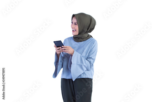 Beautiful Hijab woman is holding the phone with smiley and surprises expressions. Isolated on white background