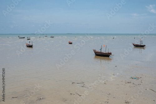 Many small boats aground on the beach with blue sky background. Small fishing boats aground on the beach.