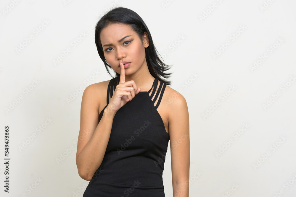 Portrait of young beautiful Asian businesswoman with finger on lips Portrait of young beautiful Asian businesswoman with finger on lips