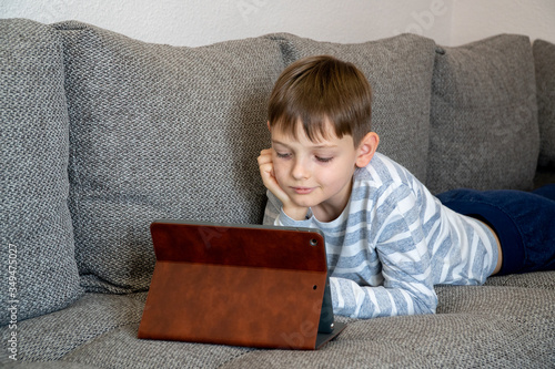 Obraz na płótnie Distance learning online education. School kid using tablet for homework. w salonie