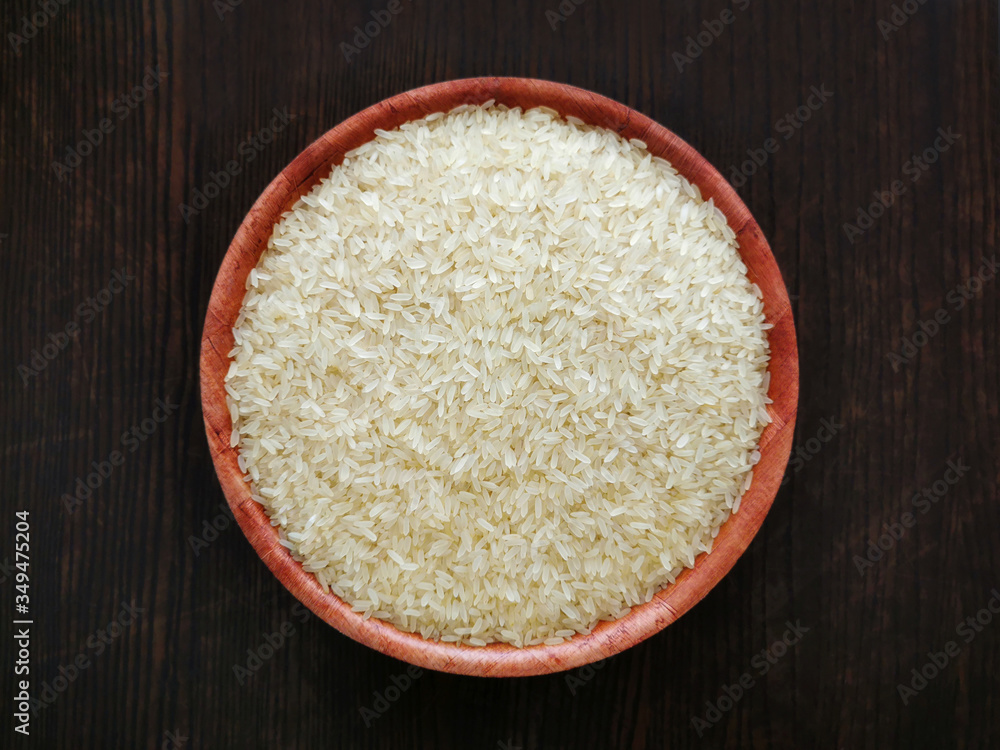 Parboiled rice on bamboo bowl on wood table. Selective focus. Top view. Parboiled rice on bamboo bowl on wood table. Selective focus. Top view.
