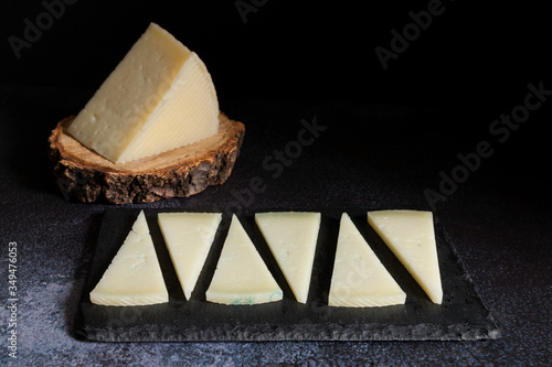  slices and piece of typical spanish manchego cheese photo