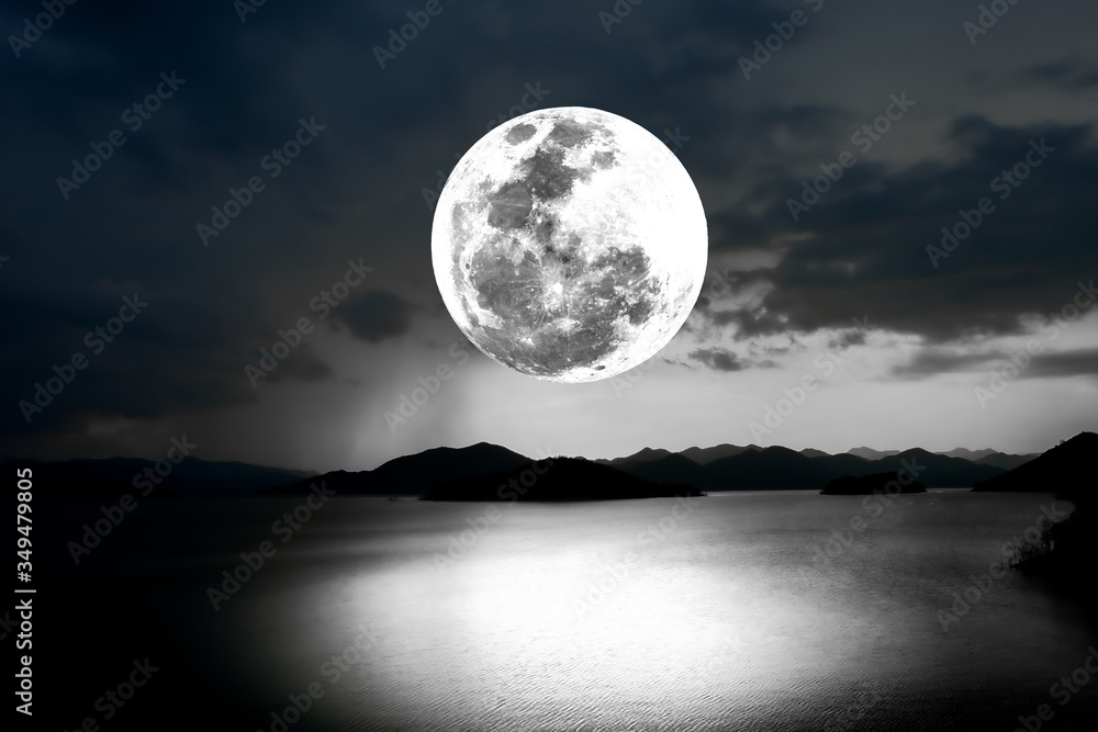 Full moon over lake at night.