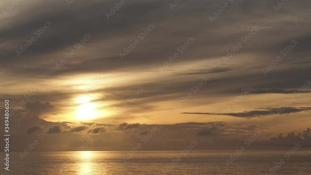 Golden sunrise over ocean, soft light clouds Golden sunrise over ocean, soft light clouds