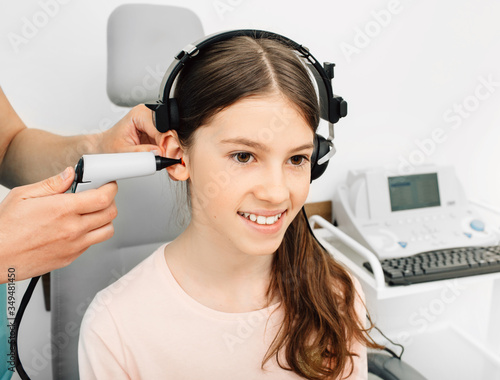 Audiologist is doing a hearing exam on a girl. Impedance audiometry. Methods for testing the middle ear in a child