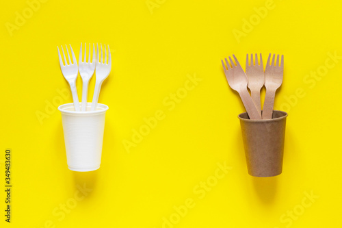 Plastic and eco-friendly disposable utensils made of bamboo wood and paper. Forks and cups. Ecology problem  zero waste concept. 