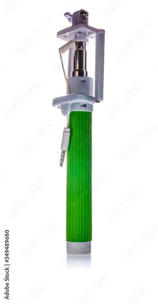 Green selfie stick for taking self portraits with camera on smartphone isolated on white background. Modern technology and social media concept. Green selfie stick for taking self portraits with camera on smartphone isolated on white background. Modern technology and social media concept.