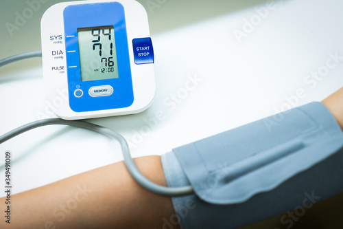 A woman doctor is measuring blood pressure of the patient that has hypertension by using automated device in the clinic in the hospital. medical and healthcare concept