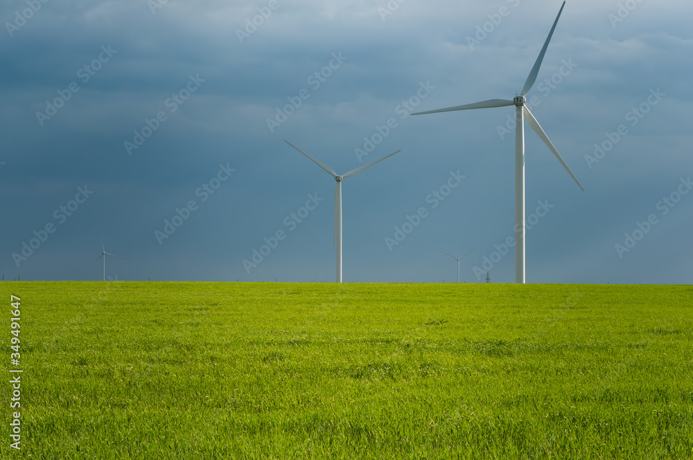 Landscape view of wind power turbine among green meadow with sky in the morning and copy space for text in the sky. Green energy concept. Landscape view of wind power turbine among green meadow with sky in the morning and copy space for text in the sky. Green energy concept.