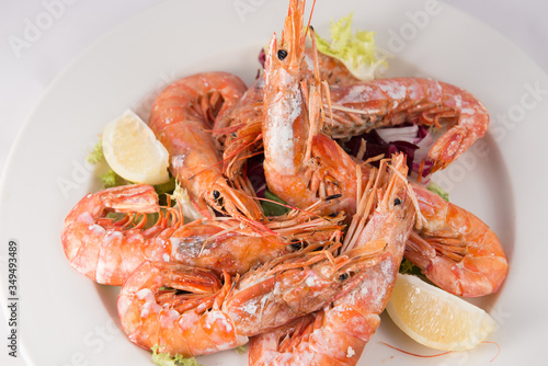 Plate of grilled jumbo shrimp with lemon and endive.