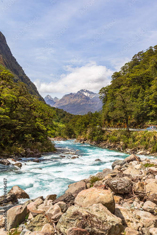 Landscape with a fast river against the background of mountains. Fiordline national park. New Zealand Landscape with a fast river against the background of mountains. Fiordline national park. New Zealand