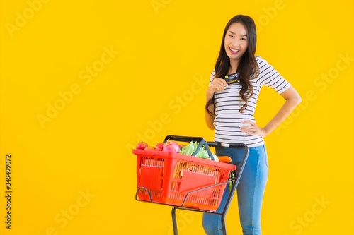 Portrait beautiful young asian woman with basket grocery and cart from supermarket