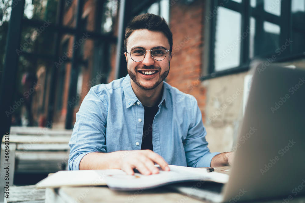 Smiling freelancer working with laptop and documents Smiling freelancer working with laptop and documents