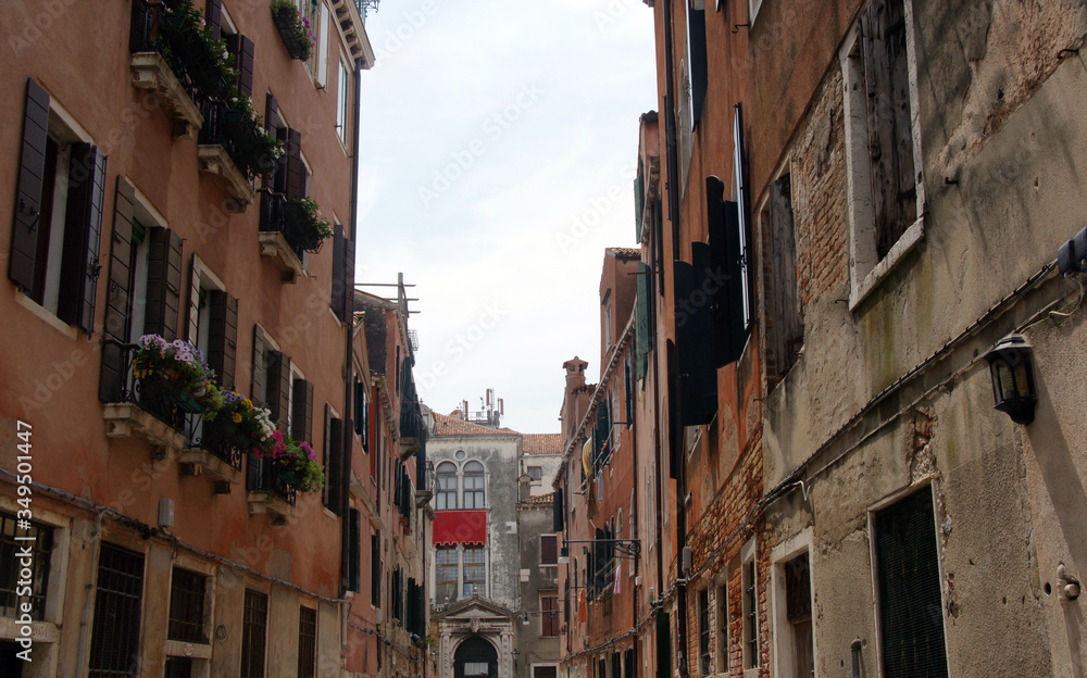 Cityscape with historical facades with flowers and shutters in Venice.