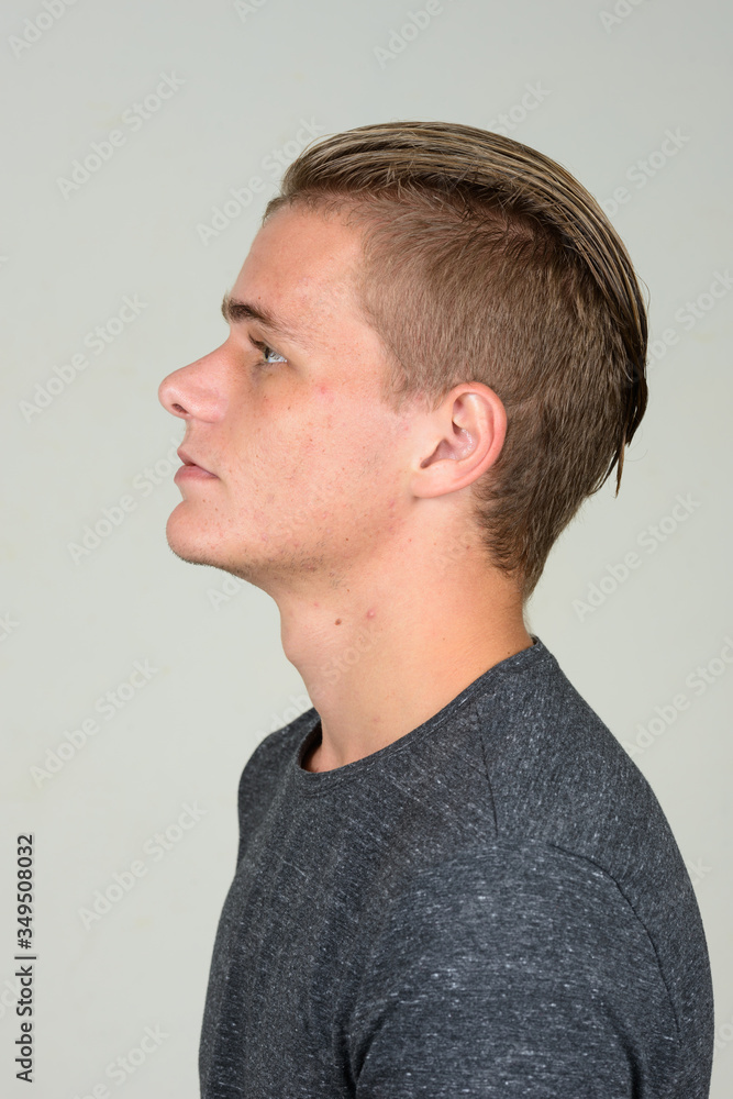 Fototapeta premium Closeup profile view of young handsome man with blond hair