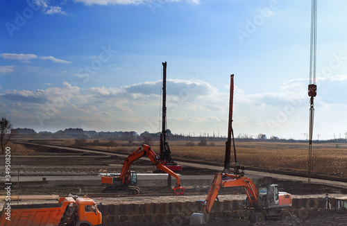 construction site with construction machines an excavator and piling machine that level the ground and drive piles